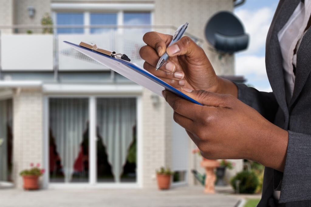 Filling out a Document in Front of a House